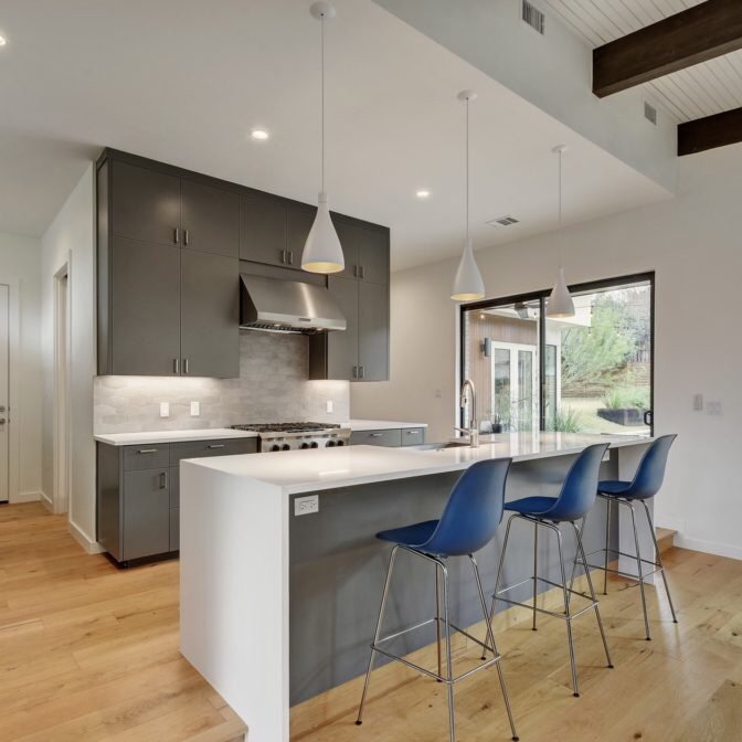 kitchen with bar top and bar seats on a hardwood floor - Peoples Signature Flooring in TX